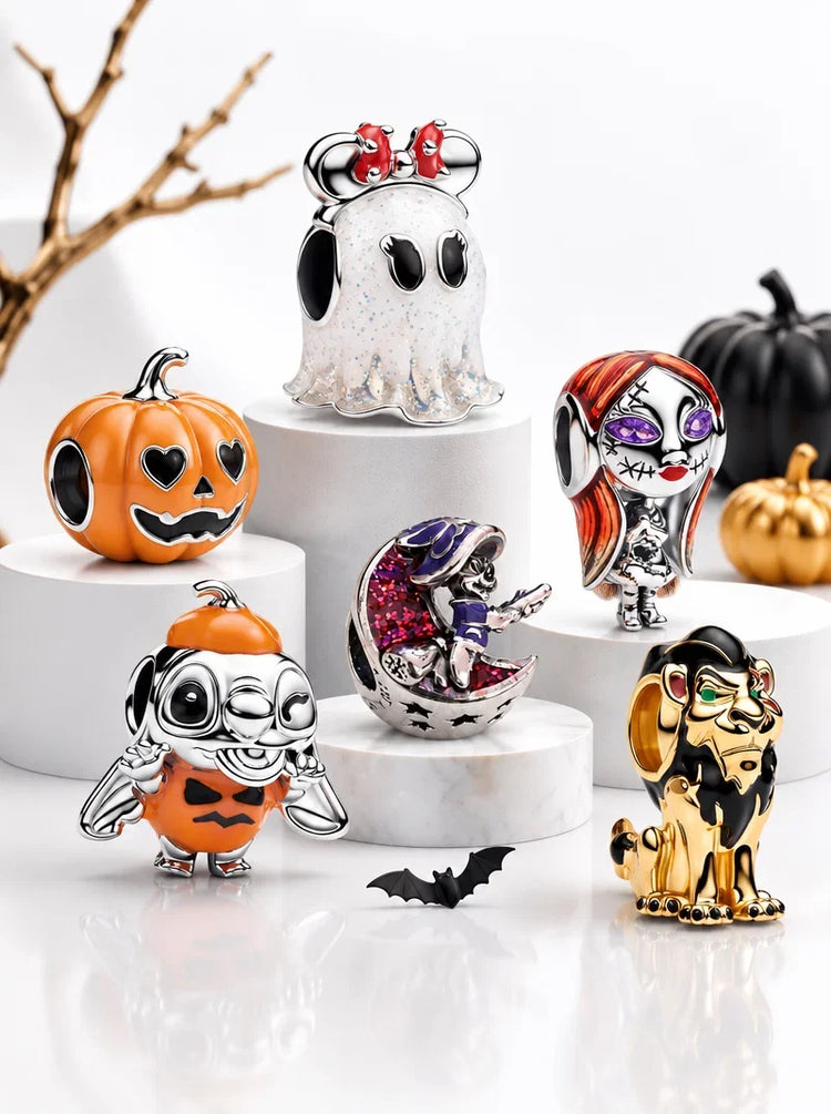 Halloween sterling silver charms with pumpkins and a bat on white display stands